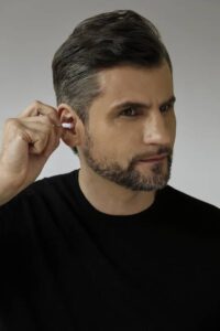 Man inserting Ceretone Core One OTC hearing aid in his ear. Photo: Ceretone